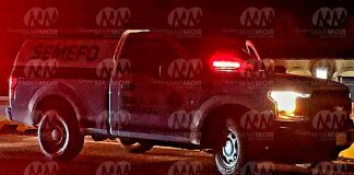 Ej3cut4n a dos masculinos frente a las letras monumentales de Tierra Caliente