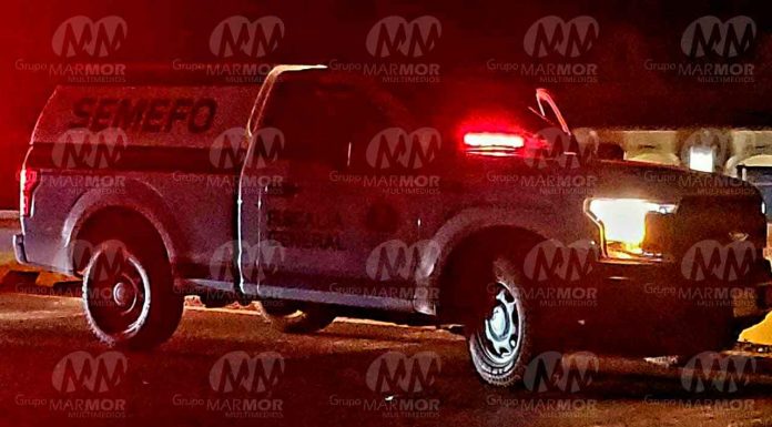 Ej3cut4n a dos masculinos frente a las letras monumentales de Tierra Caliente