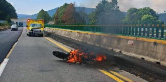 Motociclista derrapar en la Siglo XXI; la moto se incendia