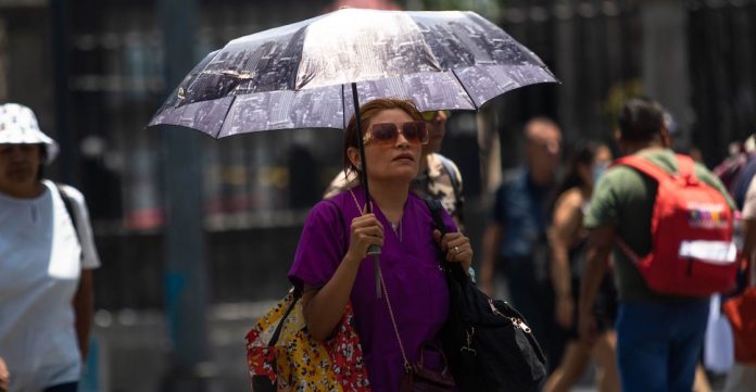 Continúa la intensa ola de calor en la capital, personas usan paraguas para mitigar los intensos rayos del sol.