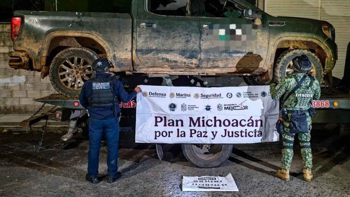 Armamento y vehículos con insignias de un grupo delictivo asegurados por autoridades en Zinapécuaro e Indaparapeo.