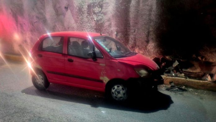 Auto compacto rojo accidentado contra el muro de un túnel en el Distribuidor Vial Salida a Salamanca, en Morelia.