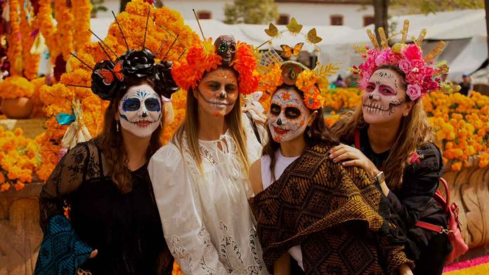 turismo-internacional-nacional-noche-muertos-michoacan Turistas nacionales e internacionales disfrutando de las tradiciones y artesanías de Noche de Muertos en Michoacán.